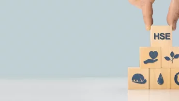 Main empilant des cubes en bois avec des icônes de santé et sécurité.