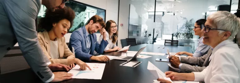 Réunion d'équipe autour d'une table avec des documents.