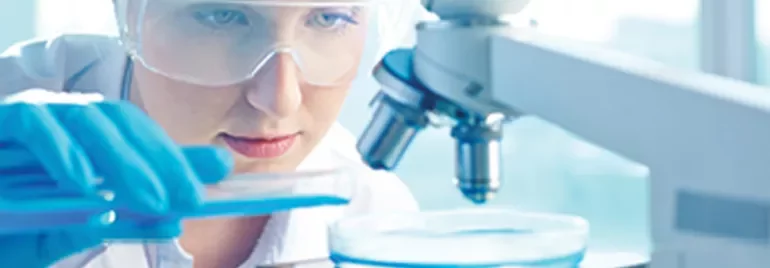 Scientifique en laboratoire examinant un échantillon.