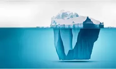 Un iceberg flottant dans la mer, avec une grande partie submergée.